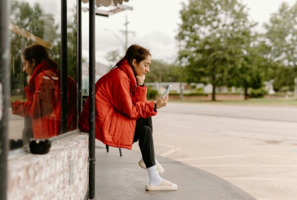 a woman sitting on a bus looking at her cell phone