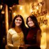 Two young women smiling at a birthday celebration.